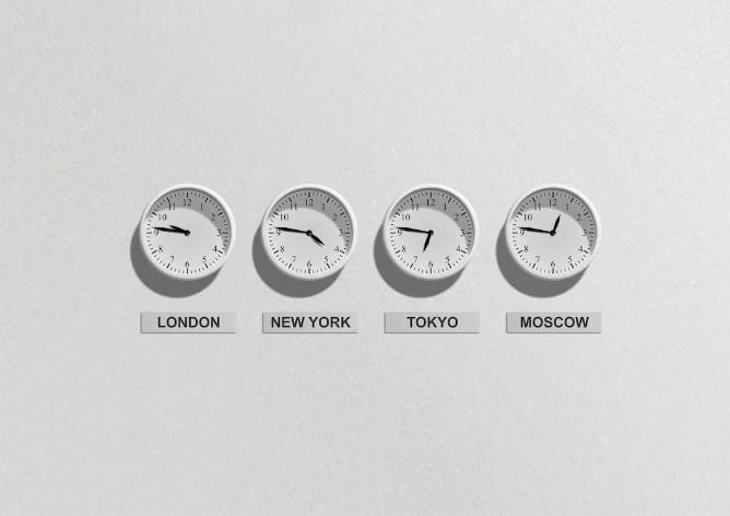 Four white clocks on the wall illustrating daylight savings time