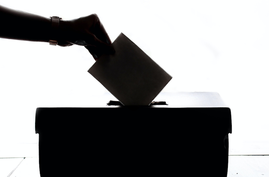 Hand putting ballot into box