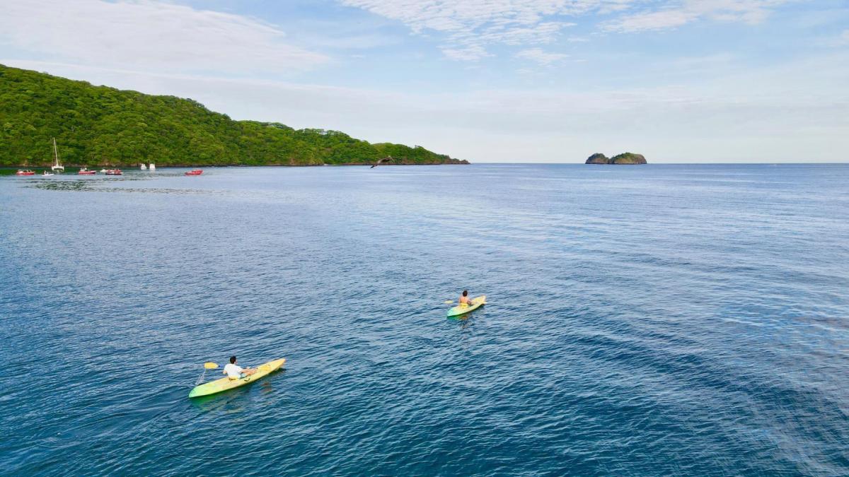 Two kayakers in the ocean off the coast of Playa Hermosa Costa Rica